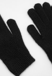 Fekete gyapjú kesztyűk bordázott textúrával, öt különálló ujjjal. Puha és bolyhos anyag, világos háttéren lefektetve.