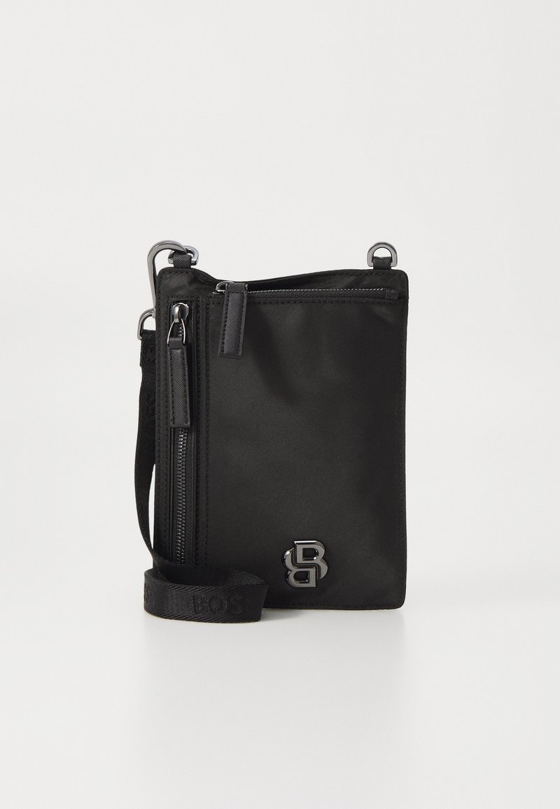 Čierna nylonová crossbody taška so striebornými kovovými doplnkami, jedným zipsom a nastaviteľným ramenným popruhom. Na prednej strane má embosovaný logo.