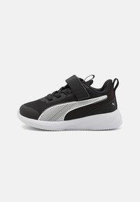 Baskets noires de sport avec tige en maille, accents blancs et bande Velcro. Elles disposent d'une semelle en caoutchouc texturé et d'une marque de signature au niveau du talon.