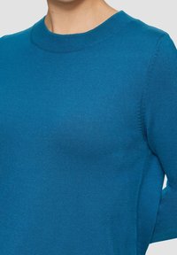 Niebieski sweter z dzianiny z okrągłym dekoltem, o gładkiej fakturze i długich rękawach, dopasowany krój z subtelnymi detalami szwów.