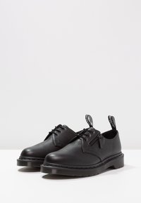 Chaussures en cuir noir à finition texturée, bouts ronds, design à lacets et fermeture éclair latérale. Dotées d'une semelle extérieure en caoutchouc épaisse et d'une languette de tirage.