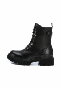 Botín negro de cuero hasta el tobillo con punta redonda, siete ojetes metálicos, diseño con cordones, suela de goma gruesa y una pestaña en la parte posterior.