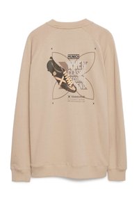 Sudadera beige con cuello redondo que presenta una gráfica de un zapato negro y el texto "MUNICH CUANDO LO CLÁSICO SE CONVIERTE EN LEYENDA" en la parte posterior.