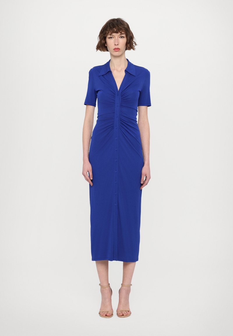Blaues, kurzärmeliges Kleid mit Knopfleiste, geraffter Textur und knielanger Schnittführung. Hergestellt aus dehnbarem Stoff. Mit einem Kragen akzentuiert.