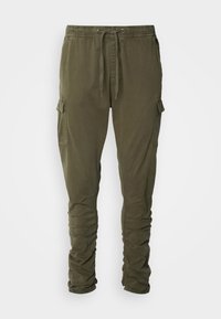 Pantalon cargo vert olive avec taille à cordon, poches latérales à rabat et détails froncés le long des jambes.