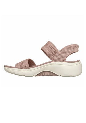 Roze sandaal met open teen, gebreide stoffen banden en een gewatteerde witte zool, ontworpen voor casual comfort en ondersteuning.
