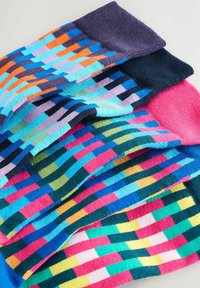Bunte gemusterte Socken mit einer Mischung aus vertikalen und horizontalen Streifen in Blau, Grün, Pink, Lila und Orange. Weiche Strickstruktur.
