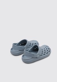 Graue Gummi-Clogs mit glatter Textur, offenem Design mit Belüftungslöchern und einem Rückenriemen für sicheren Sitz. Logo am Riemen.