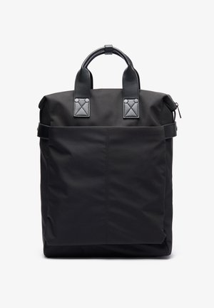 Zaino nero realizzato in tessuto resistente, con due manici corti, una tasca frontale e dettagli lucidi con cuciture quadrate.