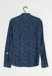 Tummansininen pitkähihainen paita, jossa on hienovarainen kuvio ankkureista ja meriteemaisista elementeistä. Paita on valmistettu teksturoidusta kankaasta ja siinä on nappihihansuut.