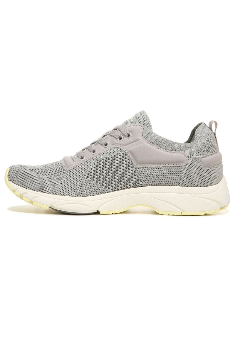 Grijze sportieve schoen met een bovenwerk van gaas, een gevoerde kraag en vetersluiting. Heeft een witte middenzool en een gele accent op de buitenzool.