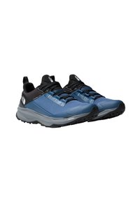 Zapatos de exterior en azul y negro con una superficie texturizada, diseño de cordones y una suela gris duradera; cuentan con una lengüeta para facilitar su uso.