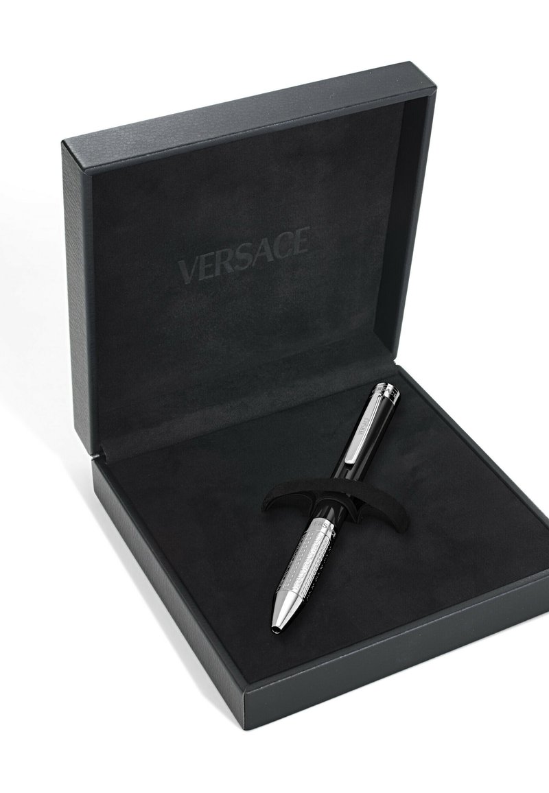 Penna Versace nera con impugnatura texture argento e dettagli cromati, adagiata in una scatola foderata di velluto nero con il nome del marchio impresso.