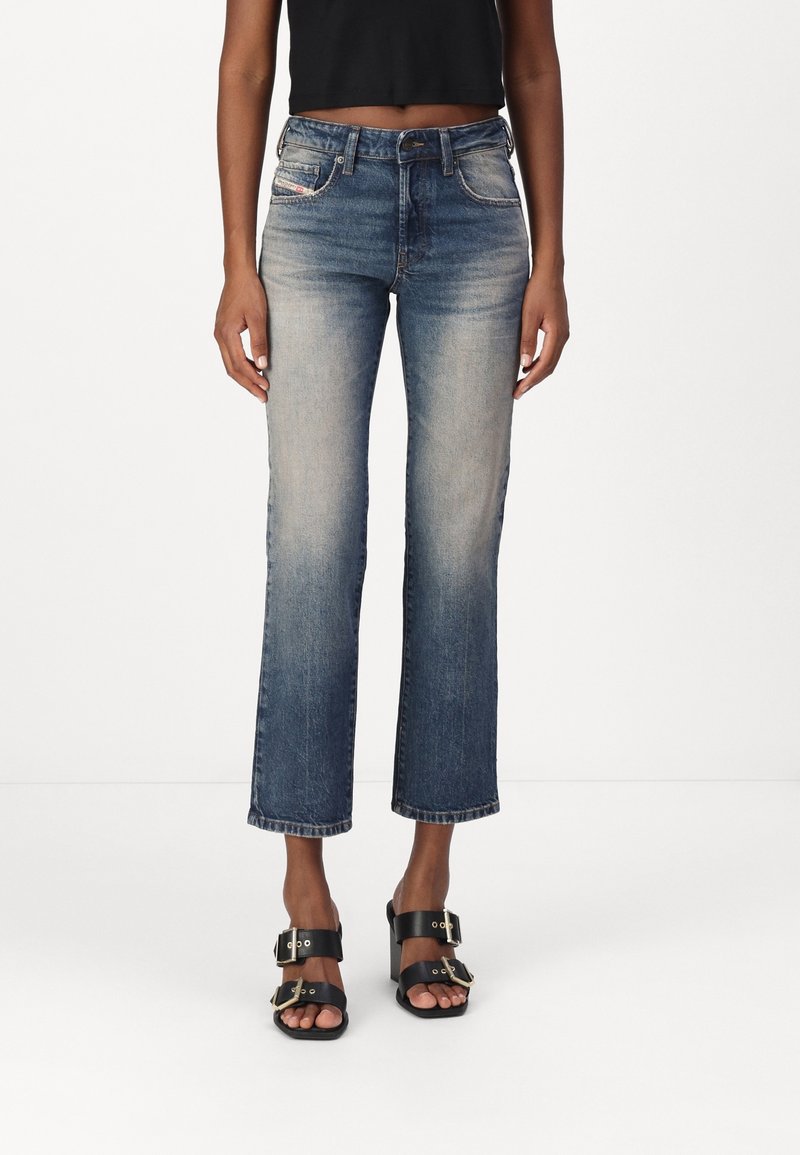 Denimjeans i en medelblå ton med rak benpassform, subtila blekning, femficksdesign och en klassisk knappstängning.