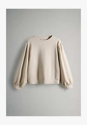 Beige sweatshirt met een ronde halslijn, drop shoulders en volumineuze lange mouwen. Zacht, gestructureerd materiaal met een cropped zoom.