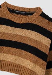 Maglione a righe in maglia con bande alternate di nero, beige scuro e beige chiaro. Colletto e polsini a coste. L'etichetta indica la taglia per età 12/13 anni.
