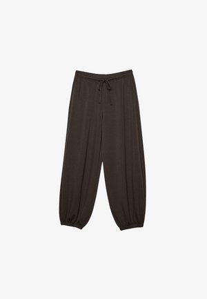 Pantaloni marrone scuro a taglio ampio con vita elastica, coulisse e polsini elastici alle caviglie su uno sfondo bianco.