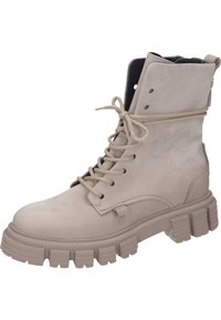 Bottine en cuir beige avec bout arrondi, devant à lacets et semelle en caoutchouc épaisse avec des rainures profondes. Détail de couture le long des coutures.