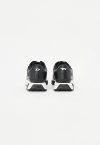 Baskets de sport noires avec un dessus en cuir texturé, dotées d'une semelle blanche et d'un logo à l'arrière. La vue de dos dévoile un design épuré.