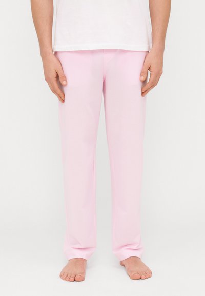 Pantalons de pyjama rose clair en coupe décontractée, fabriqués à partir d'un tissu doux. Présentent un design simple et lisse avec une taille élastique.