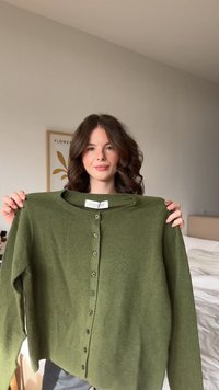 Cardigan verde oliva realizzato in tessuto morbido, con scollo rotondo, apertura con bottoni e polsini e orlo a coste.