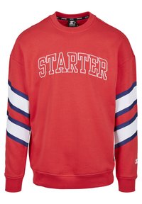 Roter Kapuzenpullover mit weißem "STARTER"-Logo auf der Brust. Verfügt über blau-weiße Streifen an den Ärmeln. Hergestellt aus weichem Stoff mit gerippten Bündchen.