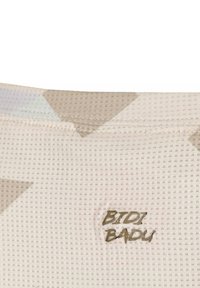 Tejido de jersey color beige claro con una superficie texturizada, presentando un logo "BTDI BADU" en dorado en relieve sobre patrones triangulares sutiles.