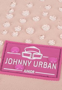 Rózsaszín textúrájú anyag, kör alakú átlátszó díszítésekkel, valamint egy lila logó folttal, amelyen a "JOHNNY URBAN" és a "JUNIOR" felirat fehér betűkkel szerepel.