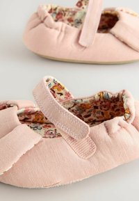 Ballerines en tissu rose avec doublure à motif floral, dotées d'une sangle Velcro et d'un dessus doux et texturé. Design à bout rond.