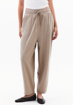Pantalons beige clair à rayures, avec une taille élastique, un cordon de serrage et des poches latérales. Texture douce et coupe décontractée.