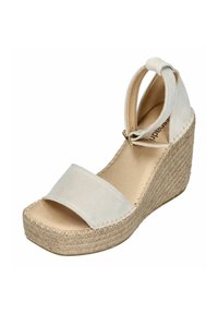 Beige wedge sandal with a canvas upper, an ankle strap with a gold buckle, and a woven jute sole. Closed toe design with a textured finish.