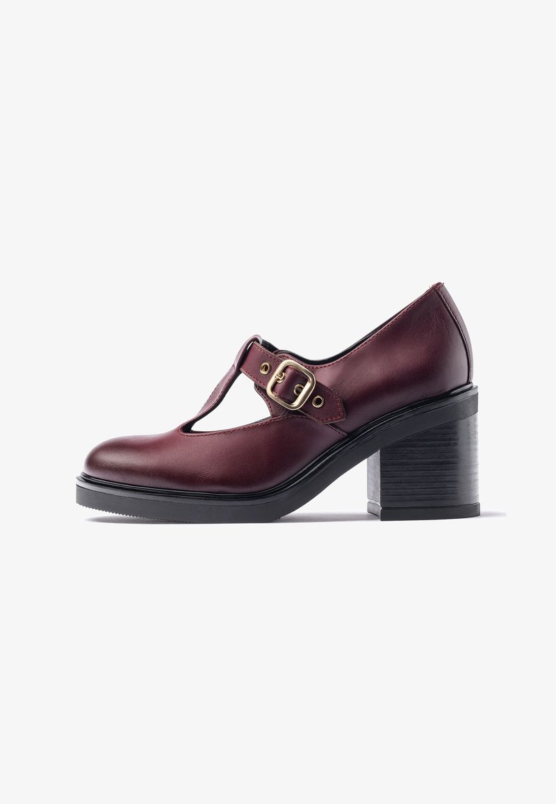 Chaussure en cuir bordeaux à bride en T avec boucle dorée, talon empilé noir épais et bout arrondi, vue de côté sur fond blanc.