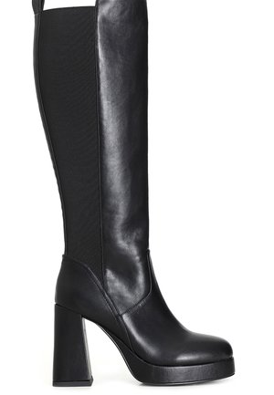 Botas negras de tacón alto hasta la rodilla con un exterior de cuero suave, paneles laterales de tela, tacón grueso y suela de plataforma para mayor altura.