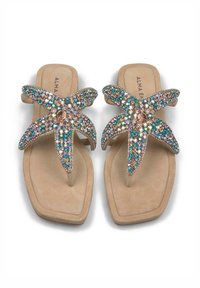 Sandalias planas tipo chancla con una suave base beige, decoradas con un diseño de estrella de mar turquesa con lentejuelas y una plantilla texturizada.