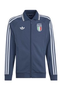Tmavomodrá športová bunda na zips s bielymi pásikmi Adidas na rukávoch, štítom Talianska s štyrmi hviezdami na hrudi a logom Adidas vpredu.