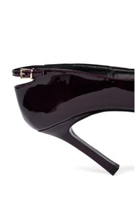 Zapato de tacón patentado en un burdeos profundo, con un diseño elegante, punta afilada y correa en el tobillo ajustable con detalle de hebilla metálica.