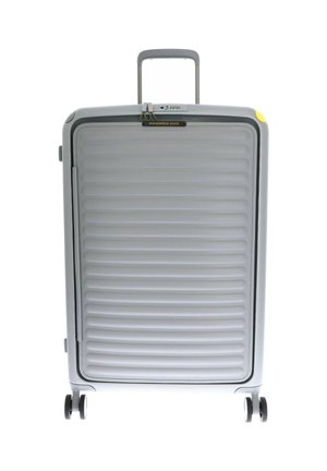 Valise rigide grise avec texture nervurée, fermeture éclair, poignée extensible et quatre roues pour la mobilité. Présente le logo de la marque sur le dessus.