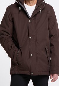 Brown waterproof jacket with a hood, zippered front, side pockets, and silver hardware accents. Features a soft lining for added warmth.