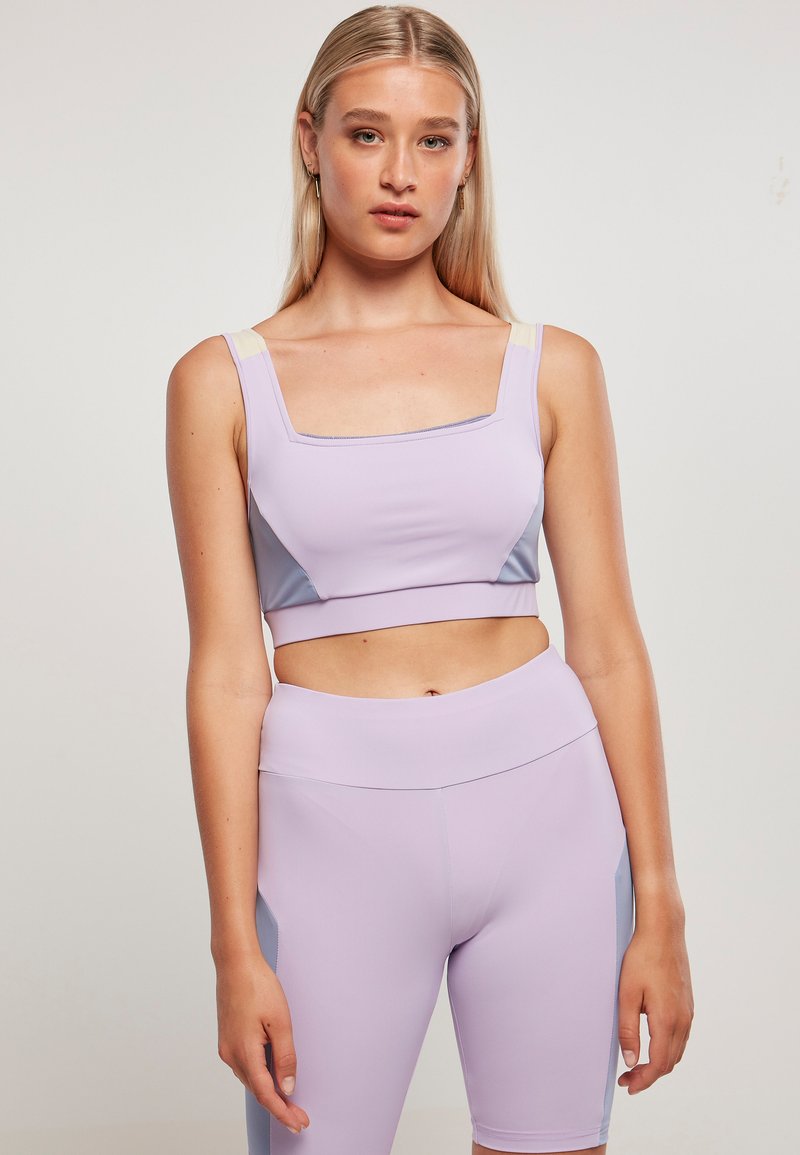 Světlolavandulový crop top a odpovídající šortky s vysokým pasem a šedými bočními panely. Hladký, elastický materiál s čtvercovým výstřihem a širokými ramínky.