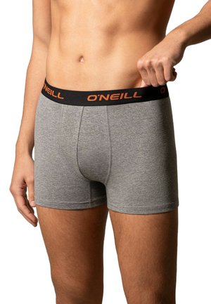 Boxer-briefs en coton gris avec une taille noire sur laquelle est inscrit le nom de la marque "O'Neill" en orange. Texture lisse, coupe ajustée et longueur mi-cuisse.