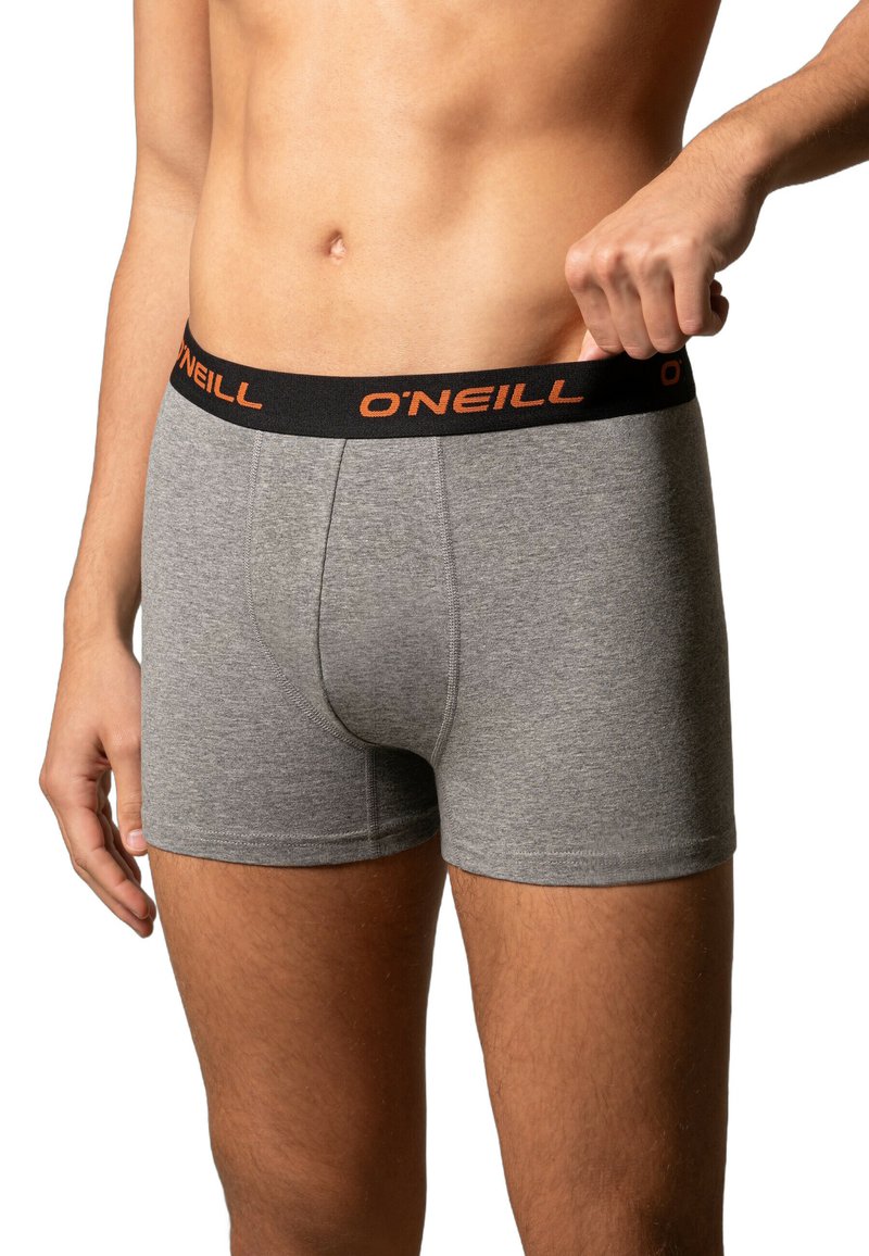 Grijze katoen boxershorts met een zwarte tailleband waarop de merknaam "O'Neill" in oranje staat. Glad textuur, aansluitend ontwerp en lengte tot halverwege de dijen.