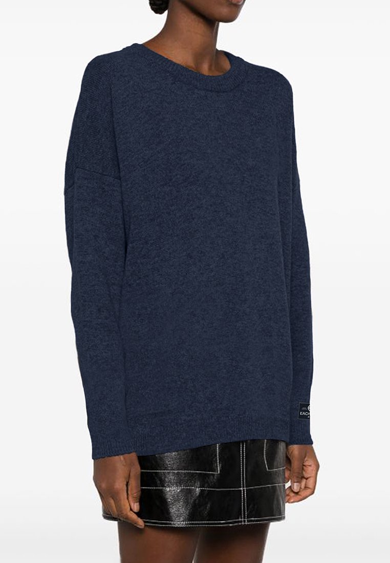Granatowy sweter dzianinowy o luźnym kroju, okrągłym dekolcie i długich rękawach. Charakteryzuje się teksturowanym materiałem i małą metką marki na dolnym brzegu.