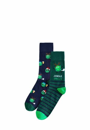 Zwei Paar Socken: eines in Marineblau mit cartoonhaften grünen Figuren und eines in Grün mit Streifen, das den Text "JINGLE SMELLS" zeigt. Material aus Baumwollmischung.