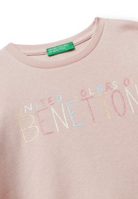 Světle růžová mikina s kulatým výstřihem a multicolor vyšitým nápisem "United Colors of Benetton" a zelenou značkovou etikou uvnitř límce.