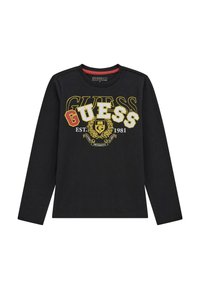 Maglietta nera a maniche lunghe con il logo "GUESS" in vari colori, con "EST. 1981" e un design di stemma al centro. Materiale misto cotone.