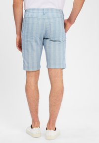 Light blue shorts made of a textured fabric, featuring a subtle check pattern, back pockets, and an elastic waistband.