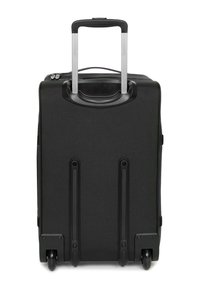 Maleta negra de carcasa dura con asa retráctil plateada, ruedas dobles en la base y superficie texturizada con ranuras horizontales.