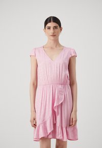 Pink dress with short sleeves, V-neckline, gathered waist, and ruffled hem. Smooth texture with subtle sheen.