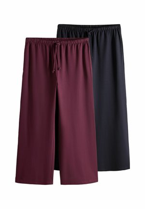 Zwei Paar Hosen mit weitem Bein, elastischem Bund und Kordelzug, eines dunkelrot und eines schwarz, flach auf weißem Hintergrund dargestellt.