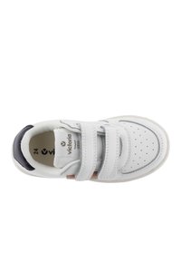 Sneaker bianca con tomaia in pelle liscia, due cinture in velcro regolabili, punta perforata e un accento grigio sul tallone. Taglia 24.